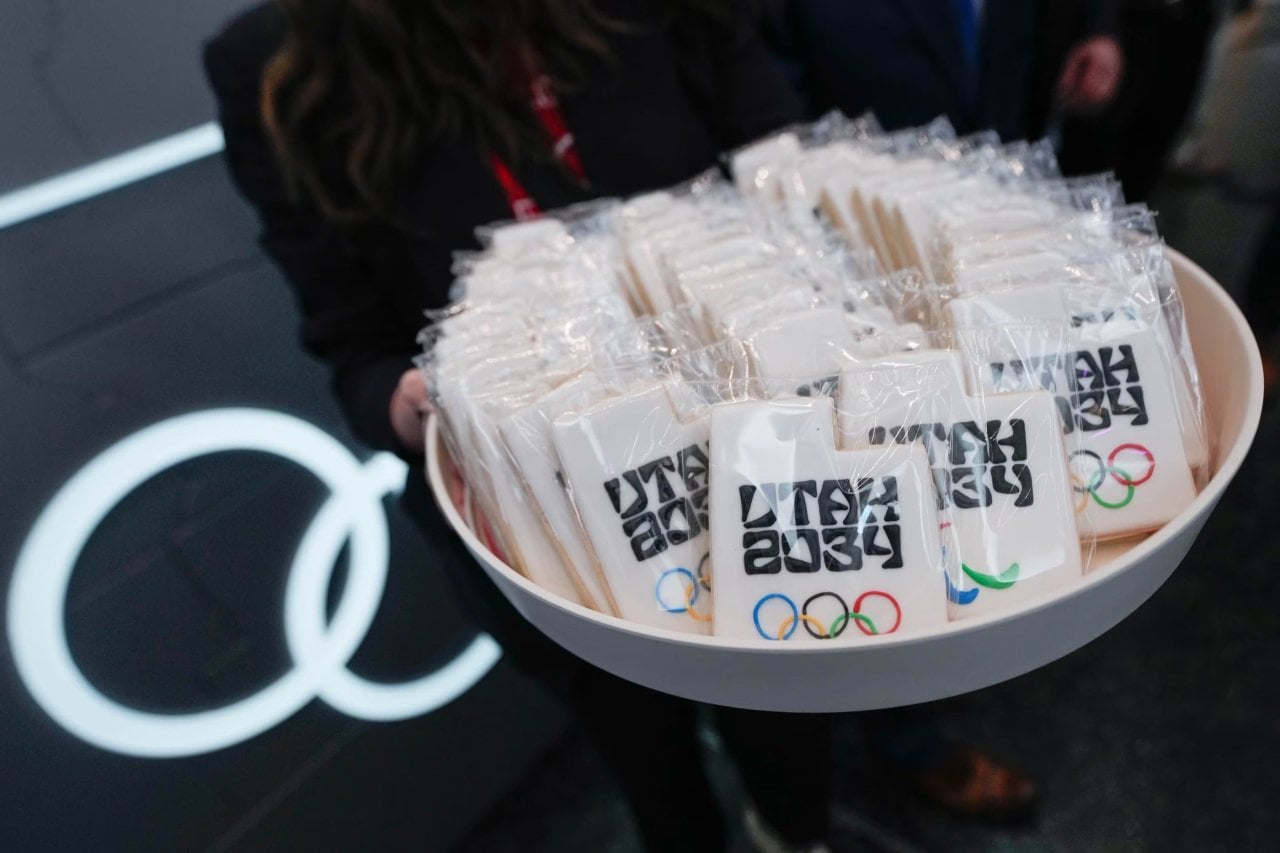Cookies in the shape of Utah decorated with icing, the Utah 2034 logo and Olympic rings are displayed in a bowl.    