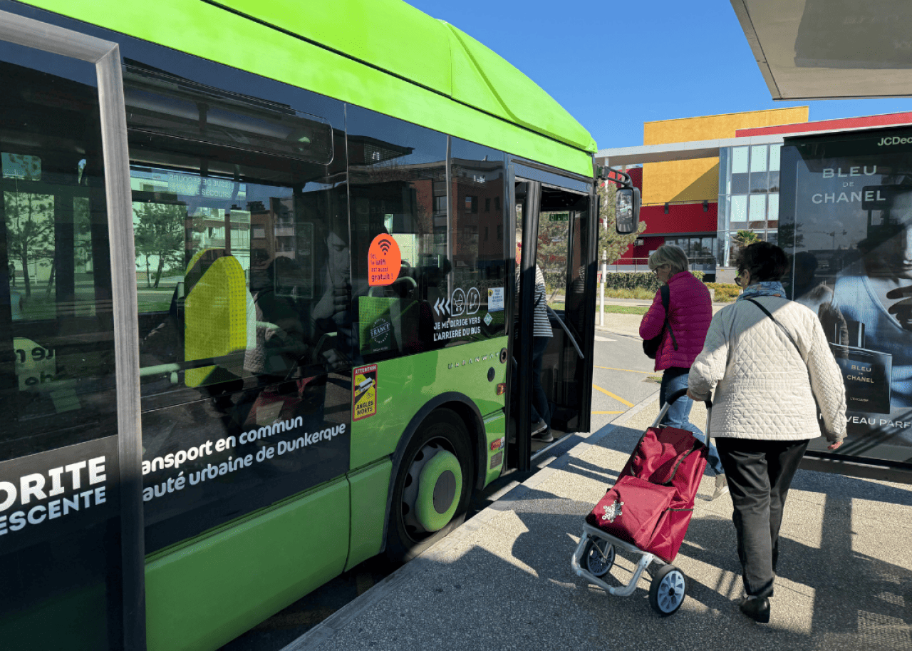 People boarding a green free city bus in Dunkirk, France.