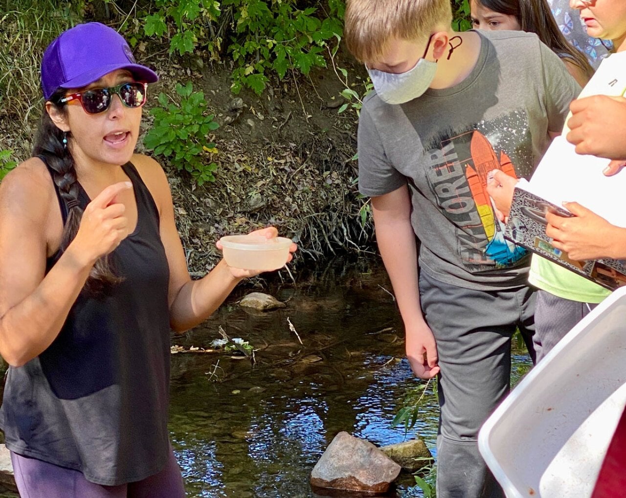 Colorado science teacher Autumn Rivera with students collecting specimens near a creek.