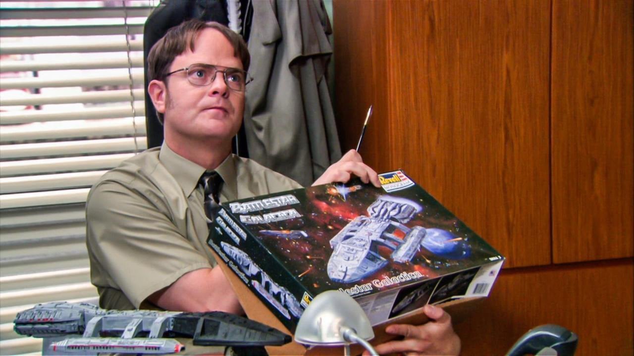 Dwight holding a Battlestar Galactica model box on The Office
