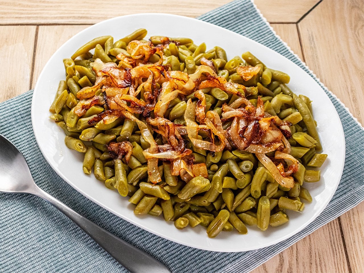 A plate of sautéed green beans with caramelized onions.
