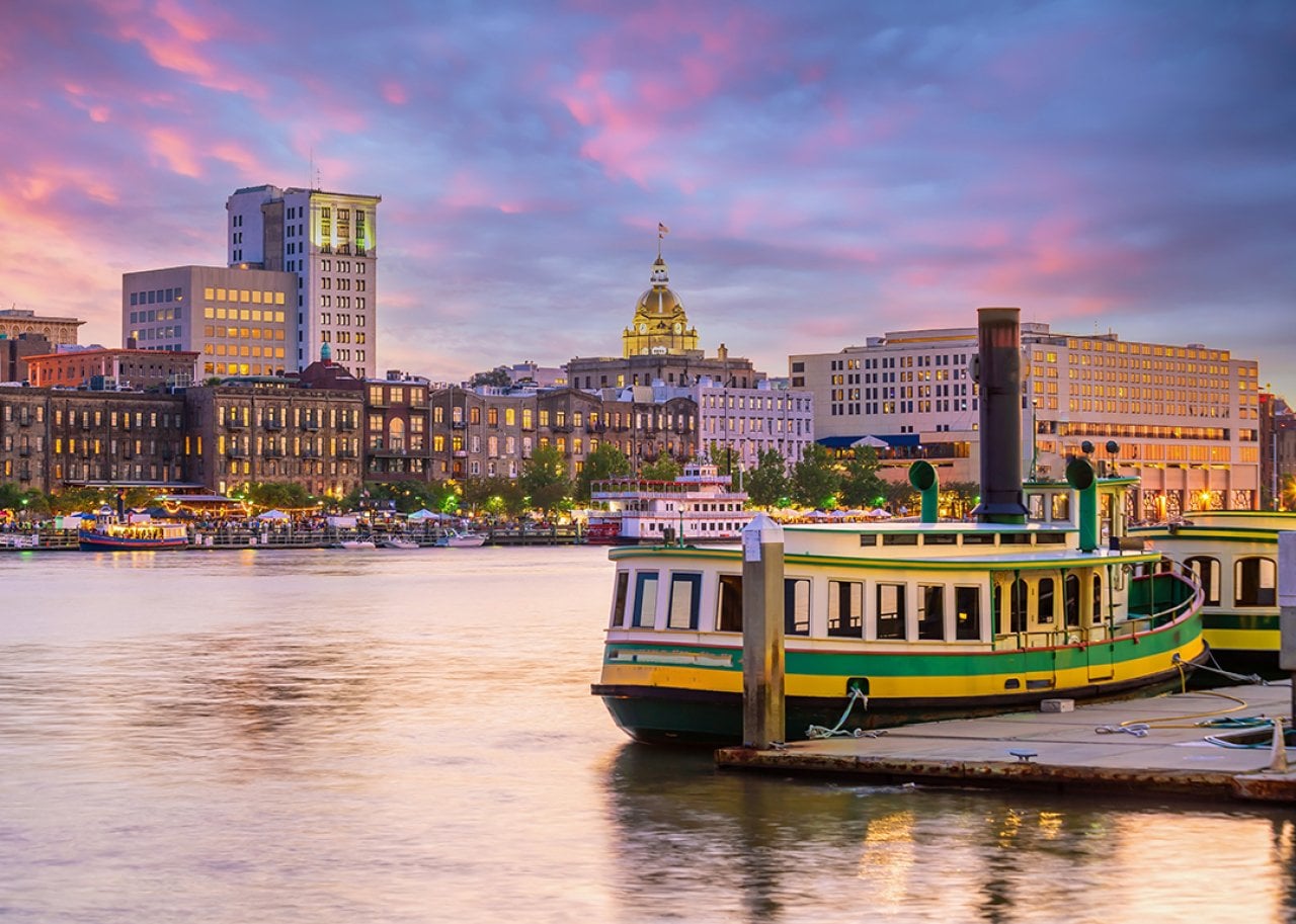 A historic district waterfront during a sunset in Savannah, Georgia, USA.