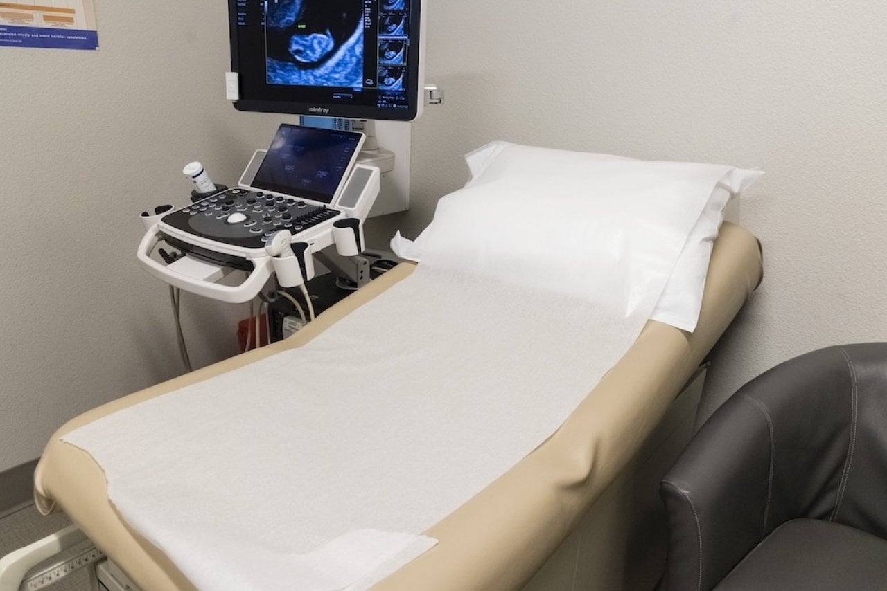 A bed and ultrasound unit in a pregnancy center, a part of life-affirming women's medical clinics operations.