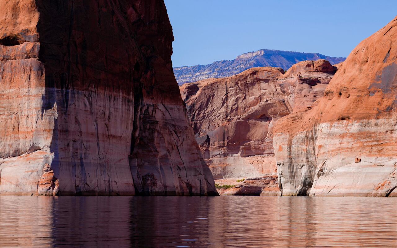 The bathtub ring marked by lighter coloring on rocks where water level used to be, is visible at Lake Powell near Ticaboo, Utah.