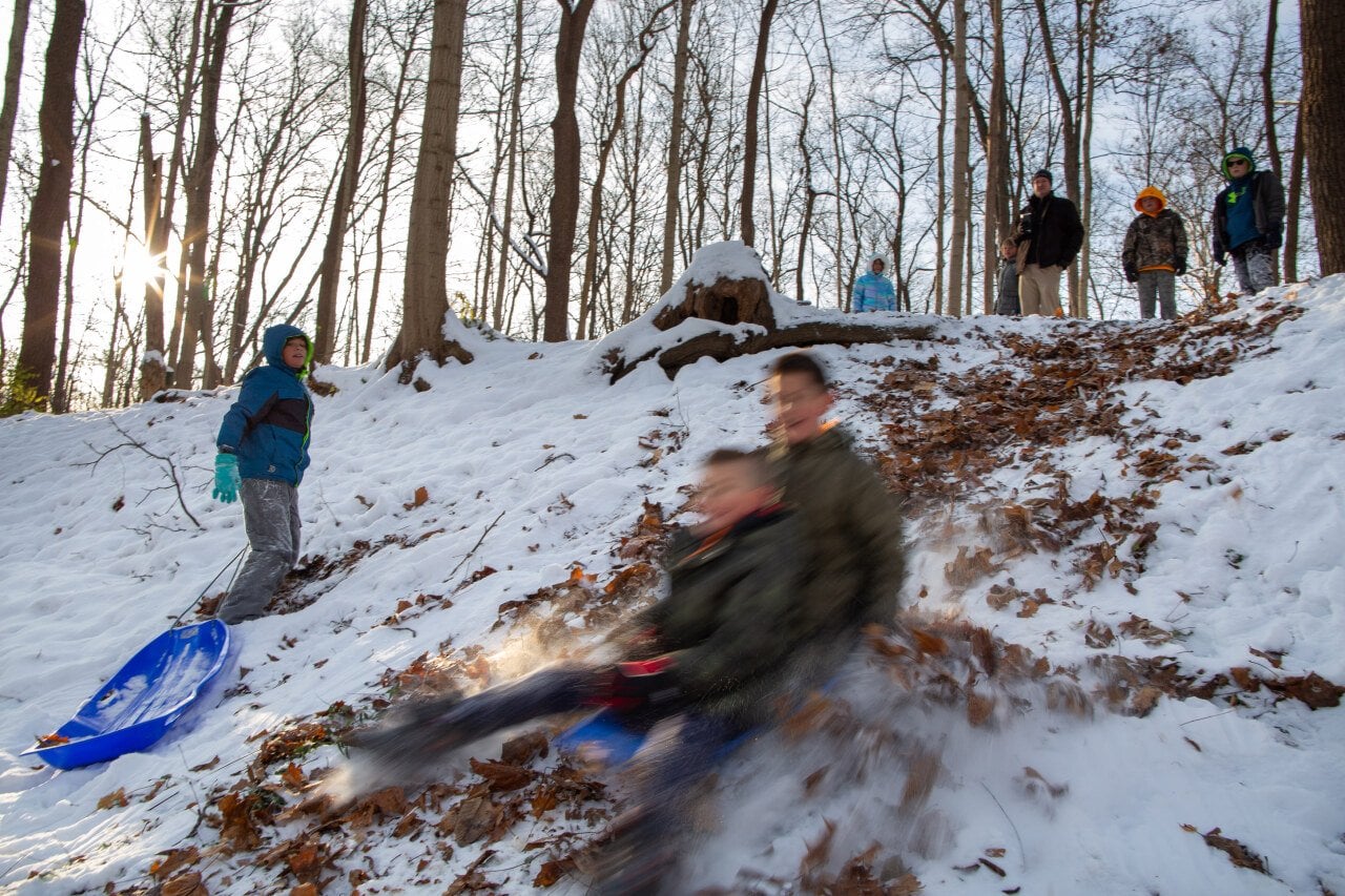 Students go sledding in the morning at Nature’s Gift Microschool at Nameless Creek in Greenfield, Ind., on Dec. 5, 2025. 