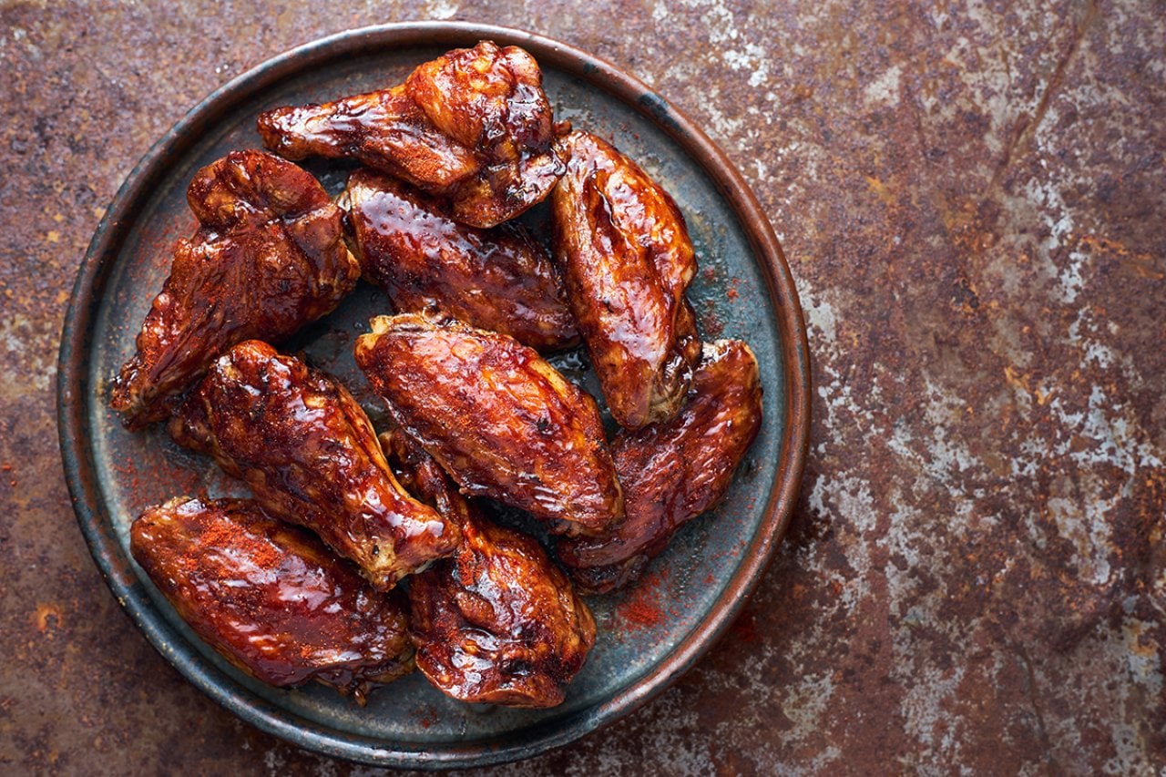 A plate of teriyaki sauce-coated chicken wings.