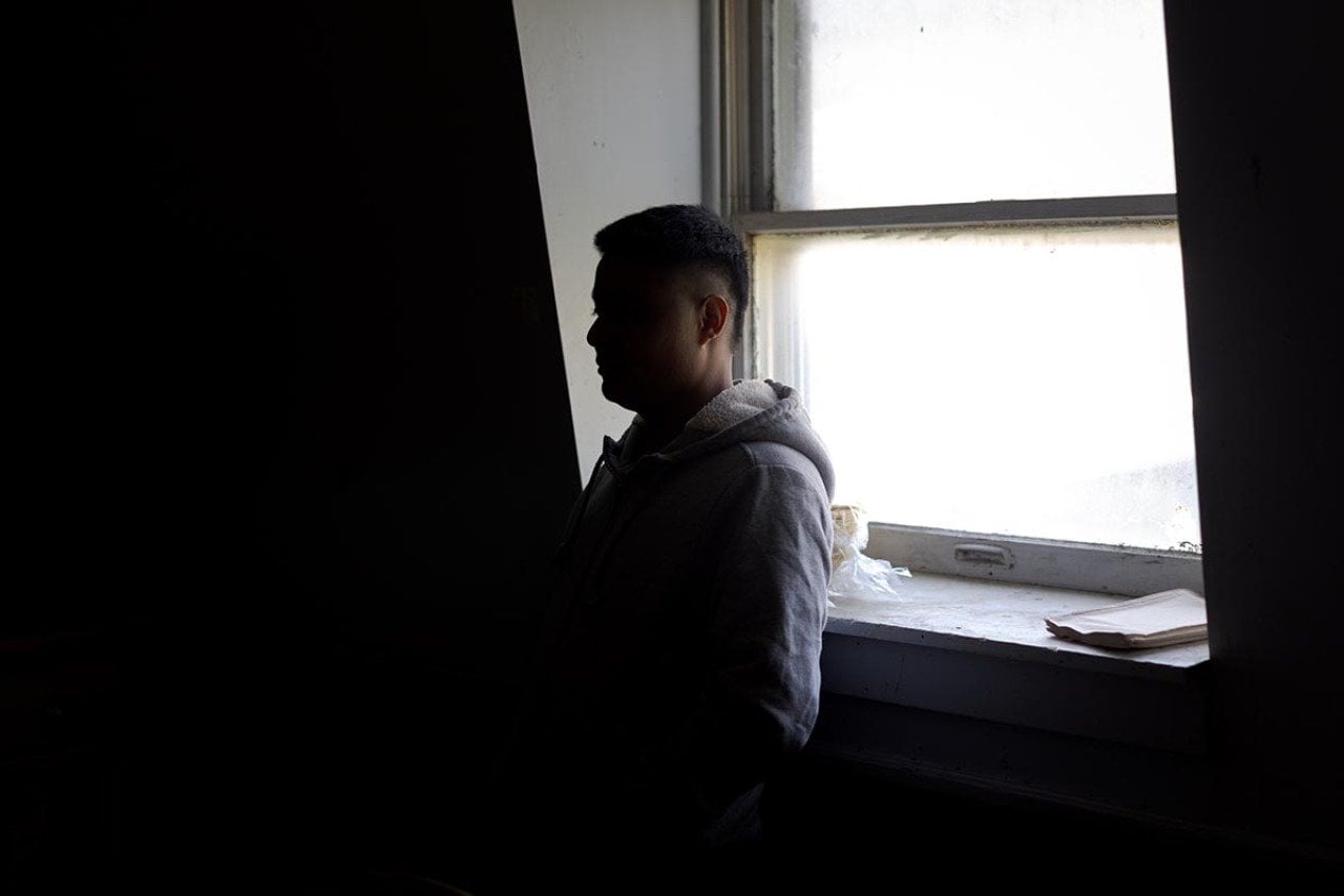 A farm worker in Vermont close to the US-Canada border, who hasn’t left the farm in almost two years out of fear of immigration enforcement stands inside the living quarters he shares with five other workers from Mexico.