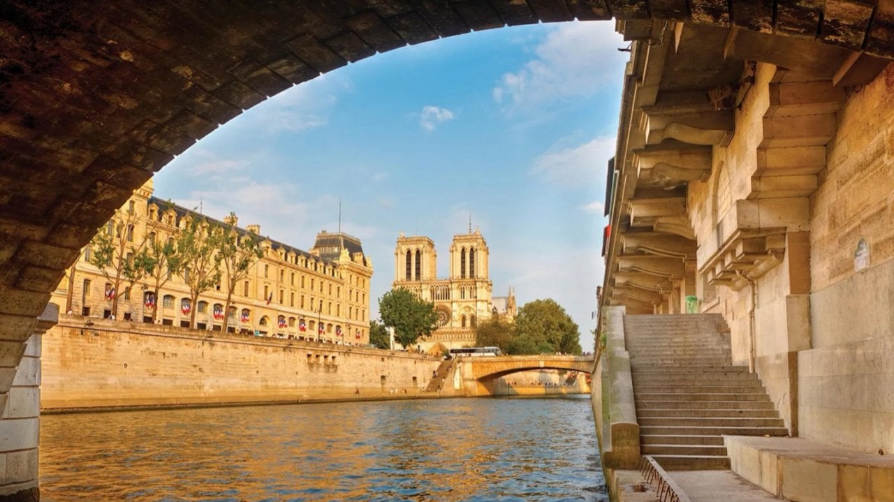 A scenic view of the Notre Dame de Paris cathedral situated along the Seine River.
