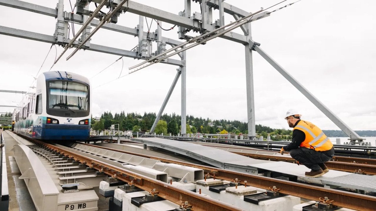 A worker crouches next to the tracks of a the $1 billion Crosslake Connection, an existing project that was behind schedule which Sound Transit aimed to finish before the world cup.