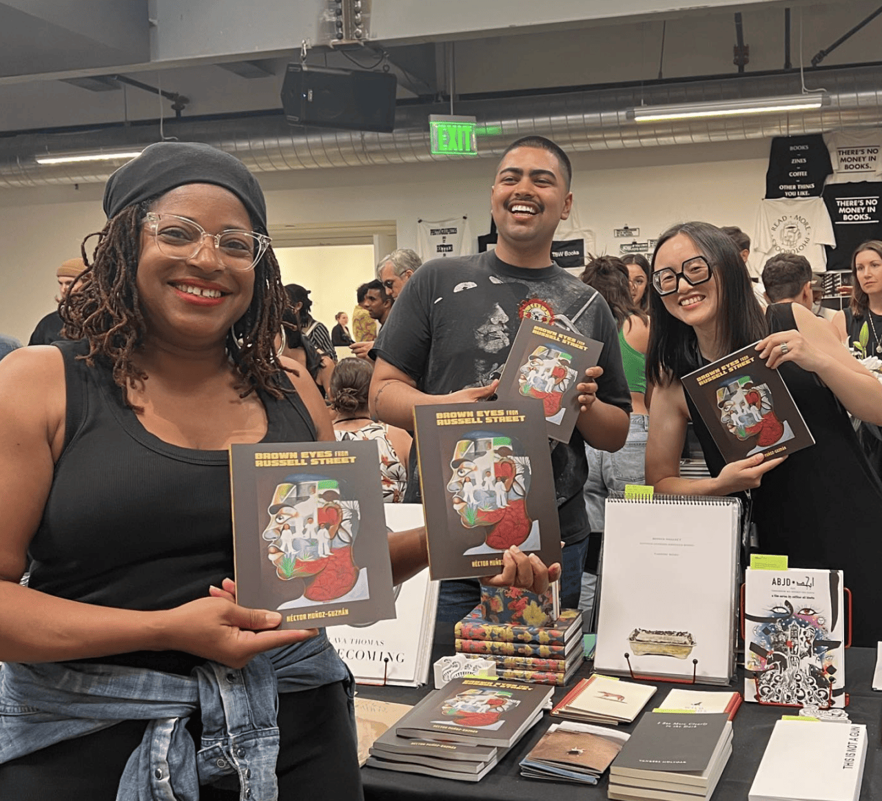 Three people holding up the book 