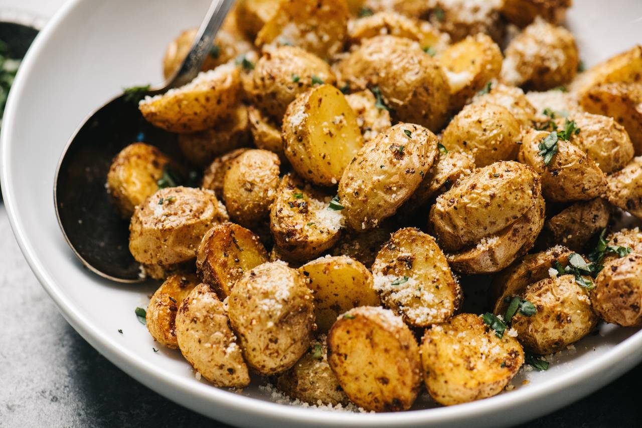 Parmesan garlic and grilled Yukon potatoes served in a plating dish.