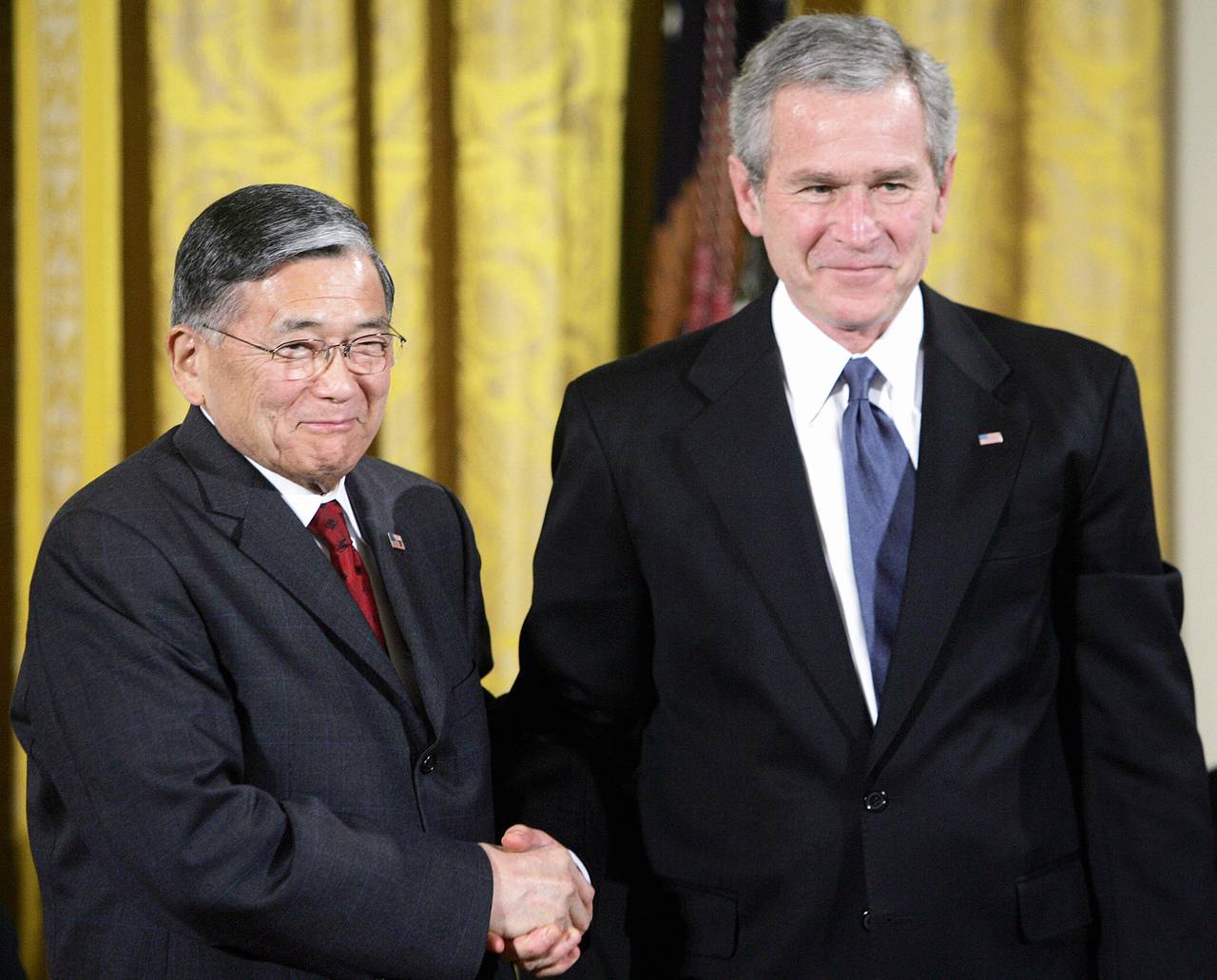 Norman Mineta (L), the longest serving secretary of transportation and former cabinet member shakes hands with former US President George W. Bush during a ceremony for the 2006 recipients of the Presidential Medal of Freedom.