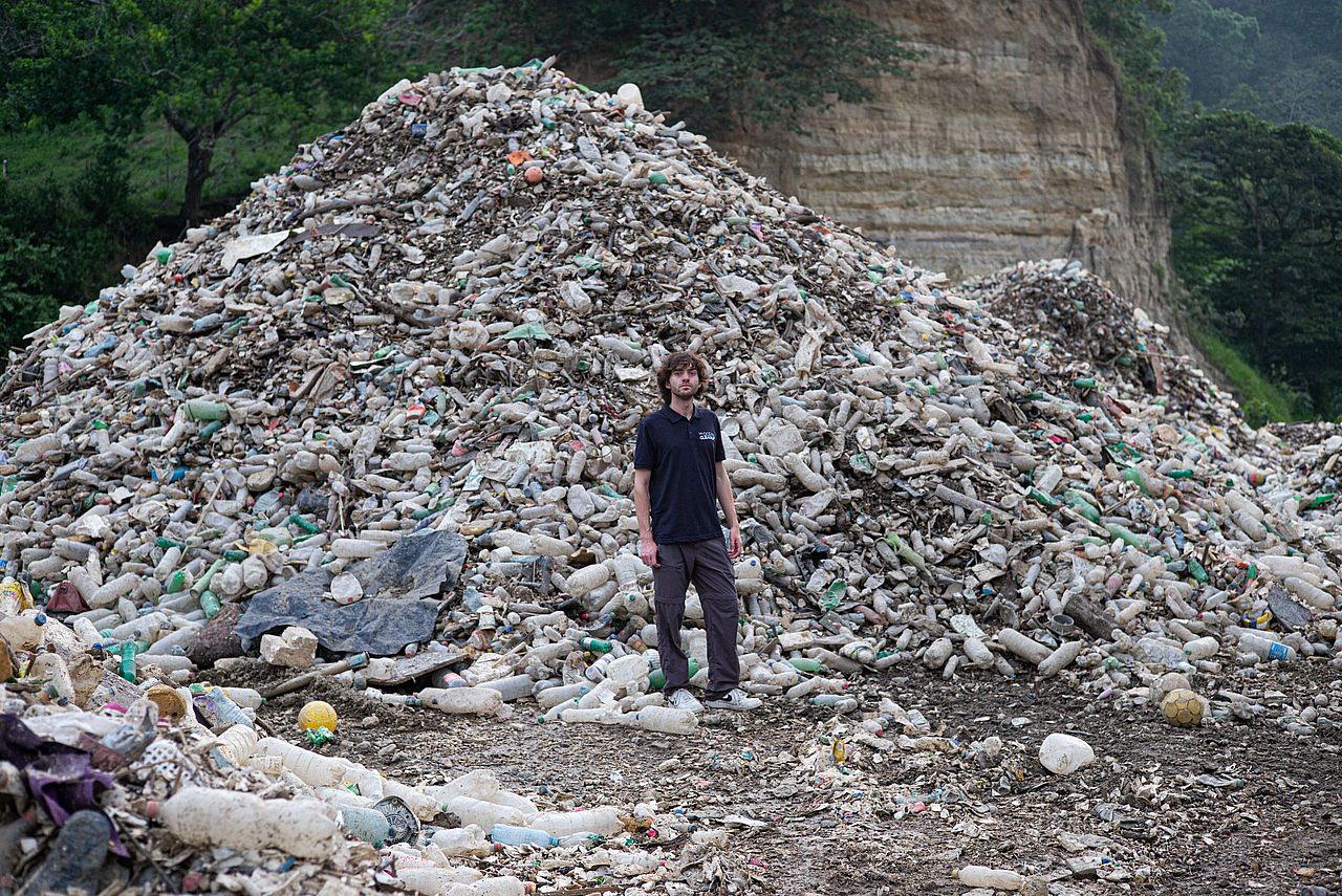 Boyan Slat standing by a pile of trash in Guatemala.