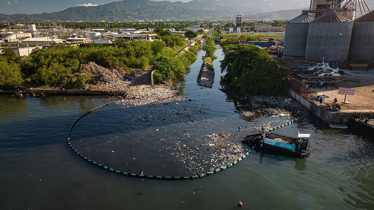 An interceptor model cleans up trash in a river.