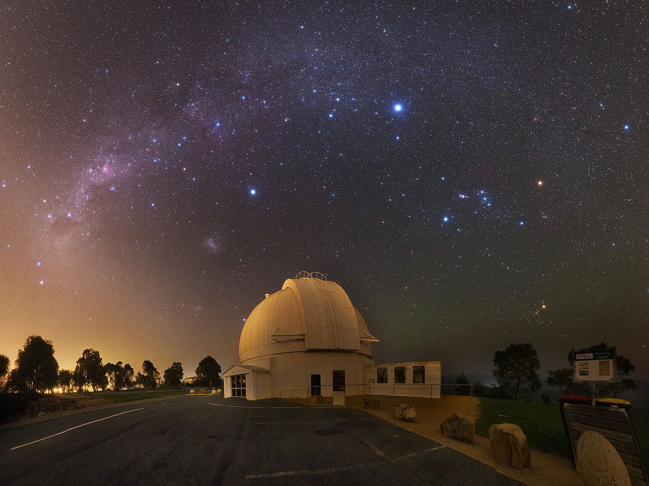 Mount Stromlo Observatory with night sky and stars visible above.