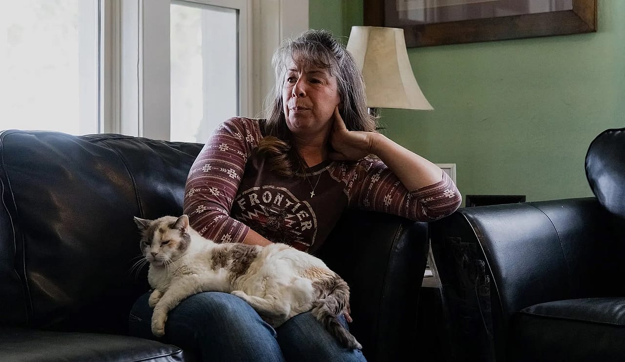 Rebecca Falcon and her cat, Baby, in her living room in Downey, Idaho.