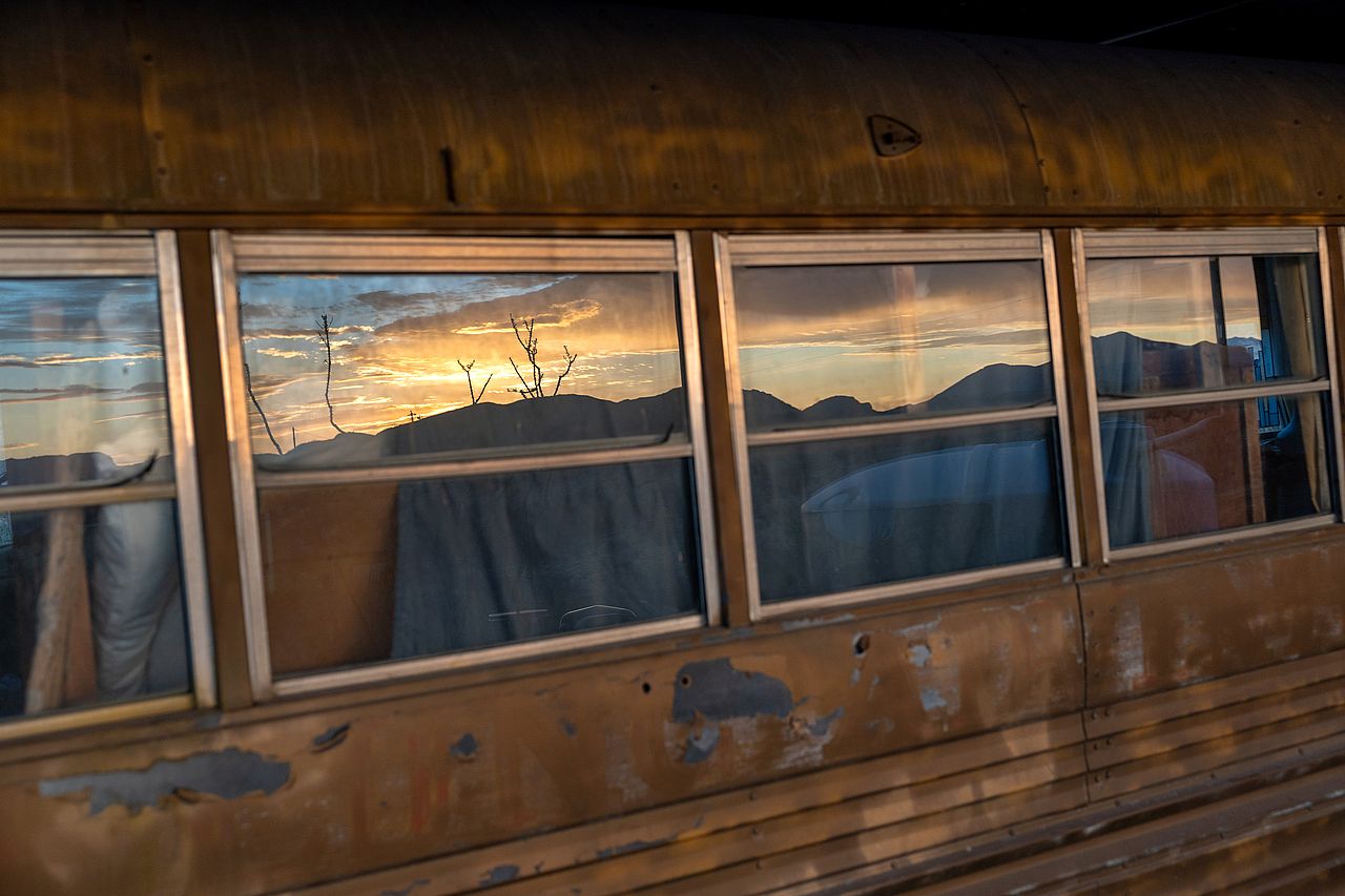 Sunrise reflecting from a converted bus used as a rental property in Terlingua, Texas, USA.