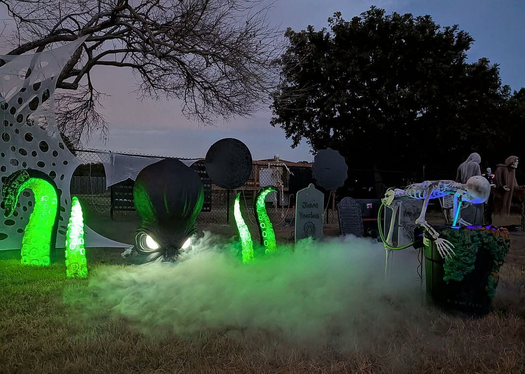 Lawn display by featuring LED lights, skeleton and smoke effects in Burleson, Texas.