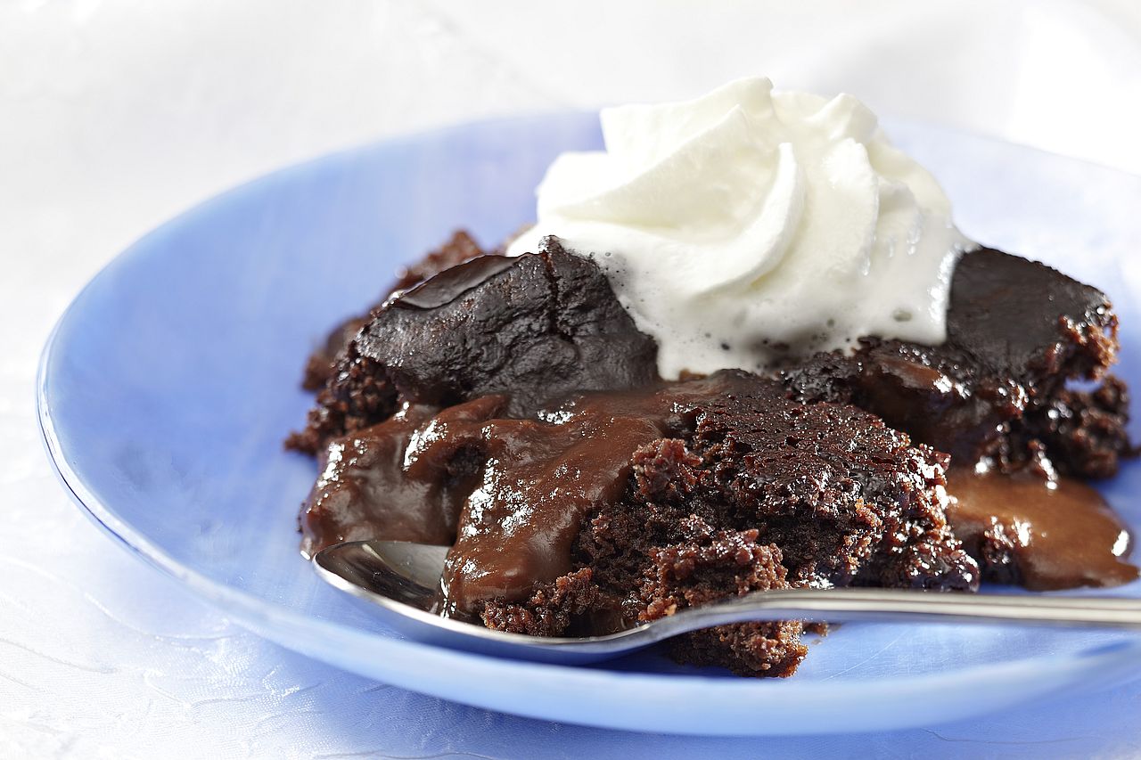 A plate of chocolate pudding with whipped cream