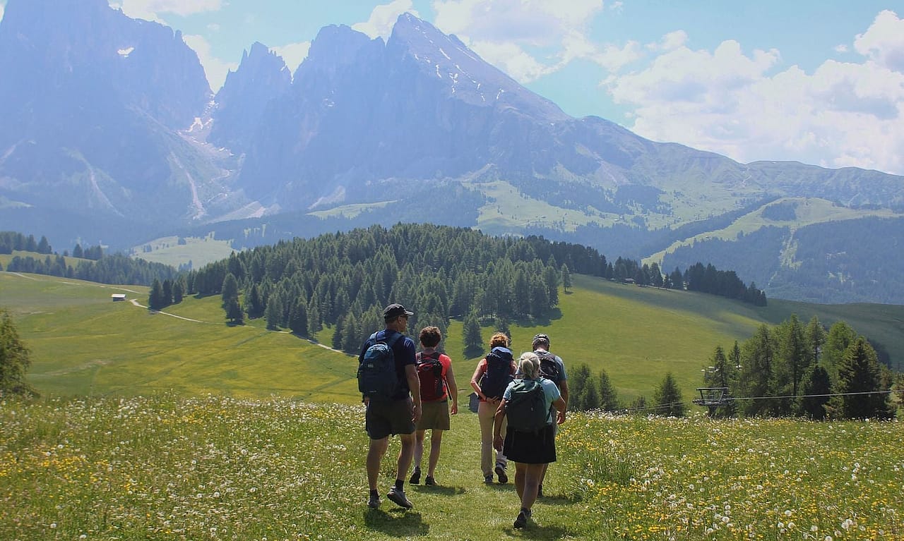 A group of hikers walking along a plateau in the Dolomites in Italy.