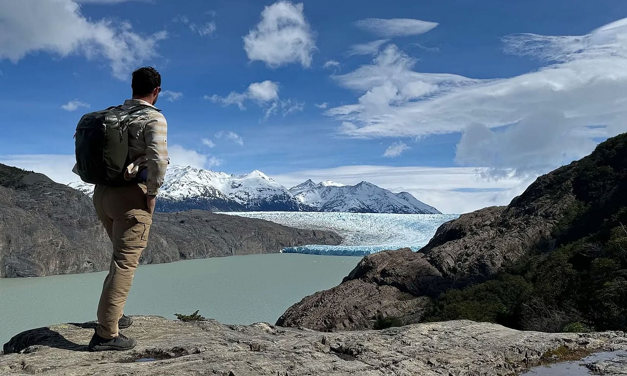 A hiker overlooking the view of view of the Grey Glacier and the Grey Lake in Torres del Paine National Park, Chile.