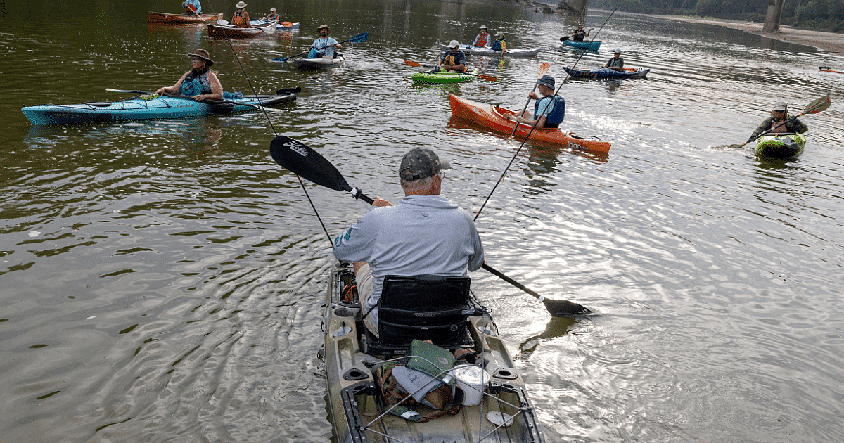 Kayakers from across Iowa joined the Chris Jones campaign for six days of paddling down the Des Moines River. Jennifer Clark (left, blue kayak) habitually carries trash bags so she can clean up the water.
