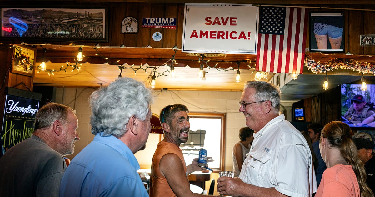 Patrons of Riverside Tavern in Lehigh, Iowa talk to Chris Jones (right) after a campaign speech.