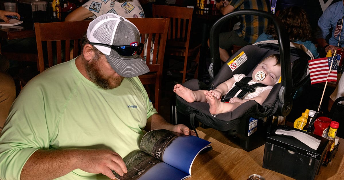 Matt Sogard brought his youngest child, Simon, asleep in a babay carrier on the table, to Jones’s event at Riverside Tavern in Lehigh, Iowa.