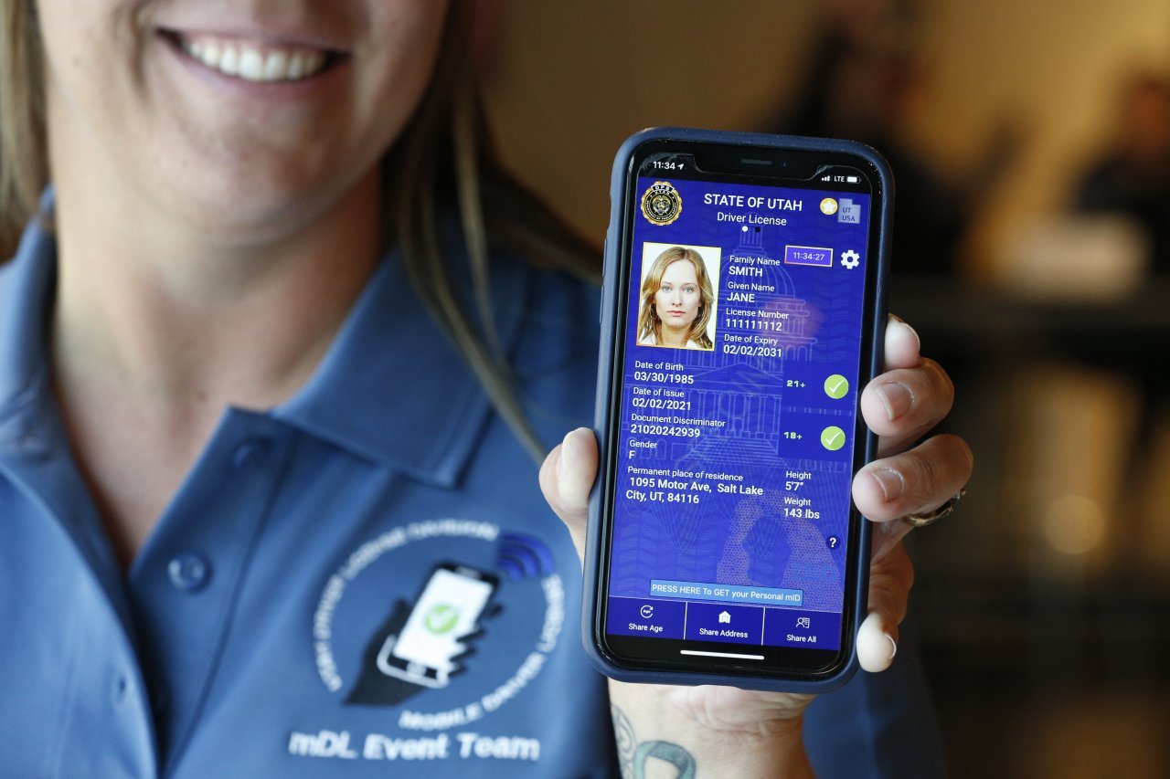 A person holding a smartphone with a mobile drivers license displayed.