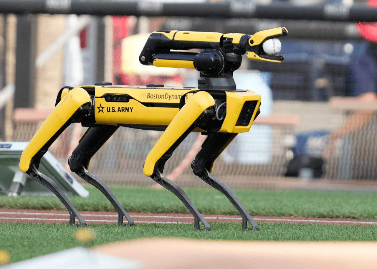 An Army robot that loosely resembles the shape of a dog on a turf field.