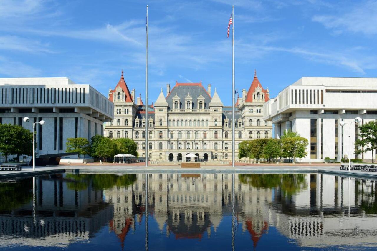 An official looking building with an American flag in front of it. 