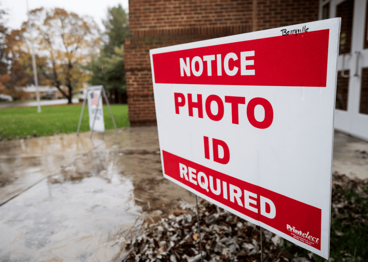 A red and white sign outside of a building that reads, Notice Photo ID Required.