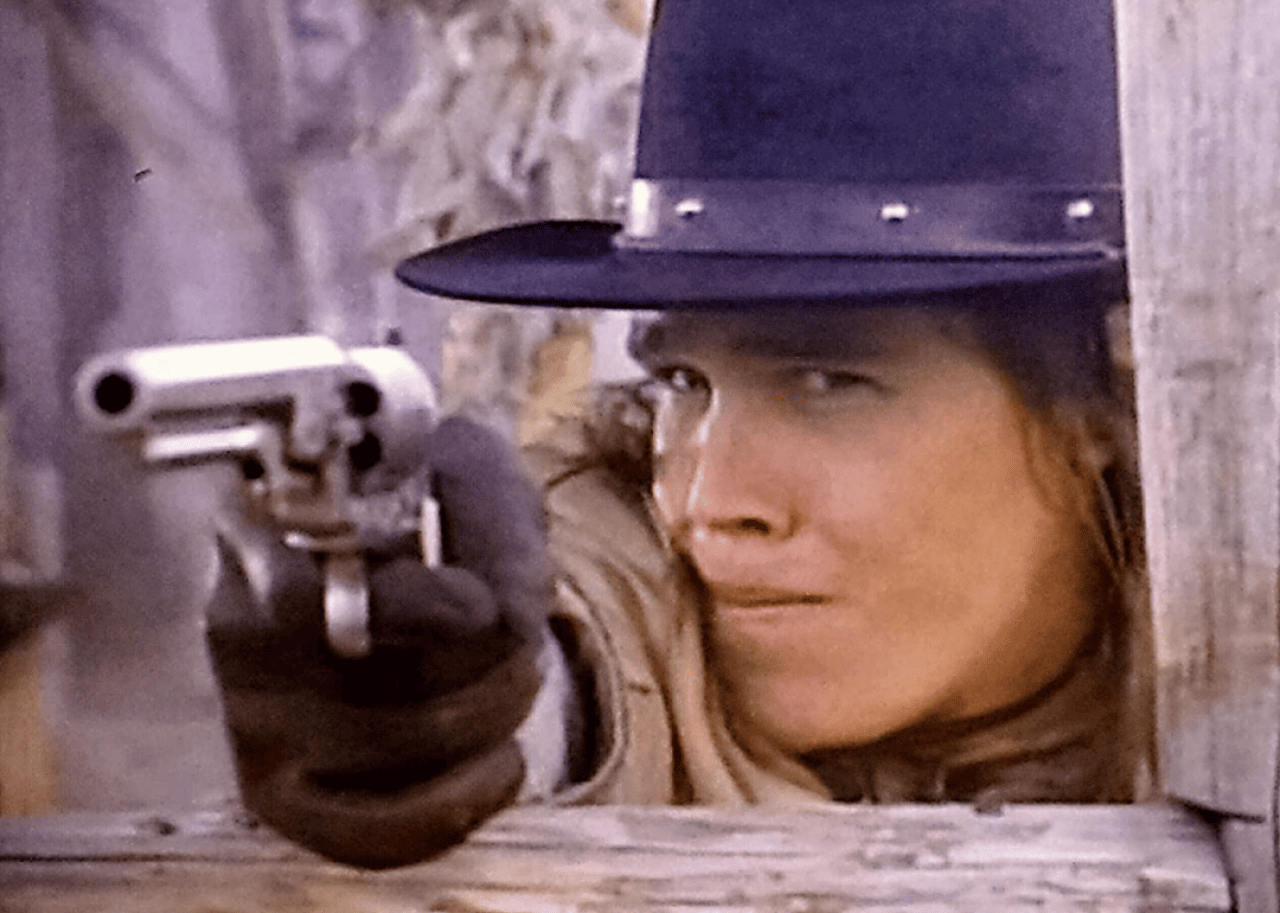 A cowboy shooting a gun.