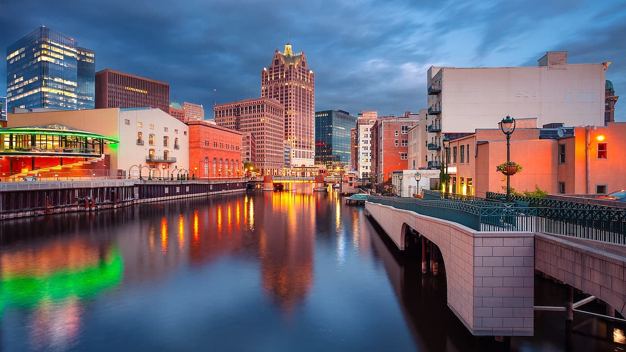 Milwaukee, Wisconsin, USA. Cityscape image of downtown Milwaukee, Wisconsin, USA with reflection of the skyline in Milwaukee River at summer sunset.