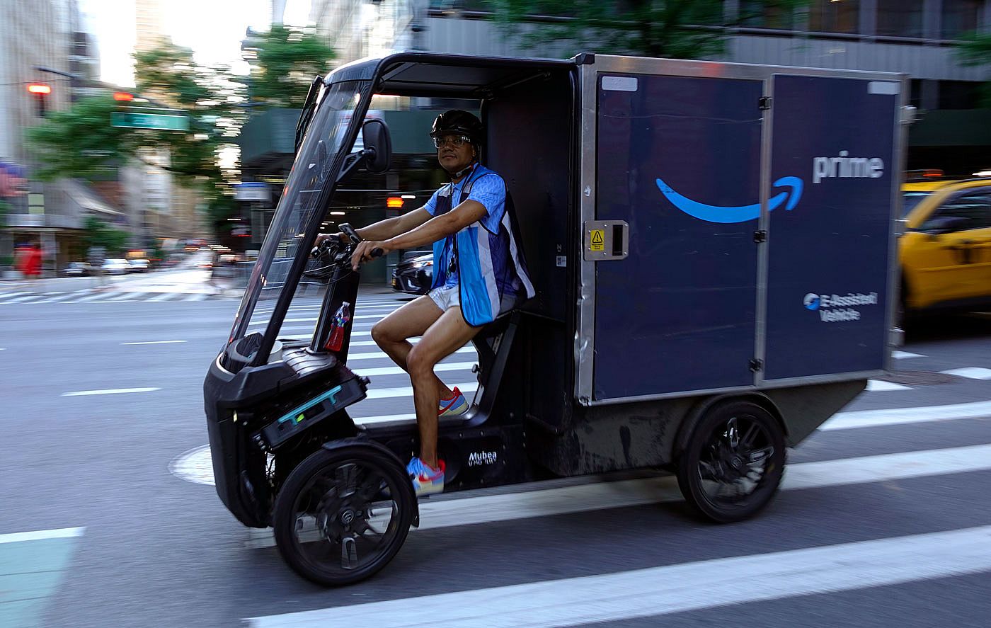 An Amazon delivery person pedals an E-Assisted delivery vehicle in NYC.