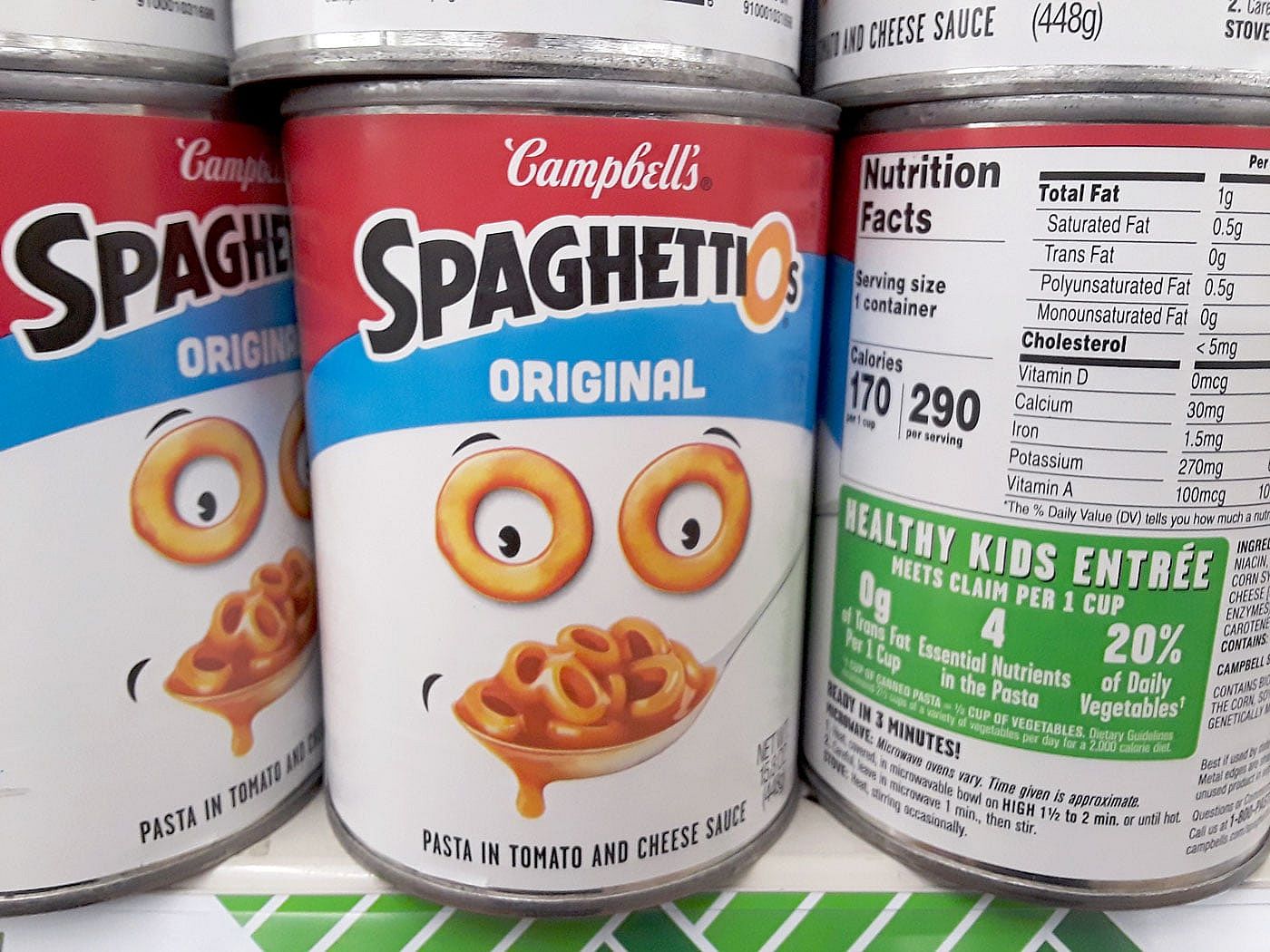 Cans of Campbell's SpaghettiOs on a grocery store shelf