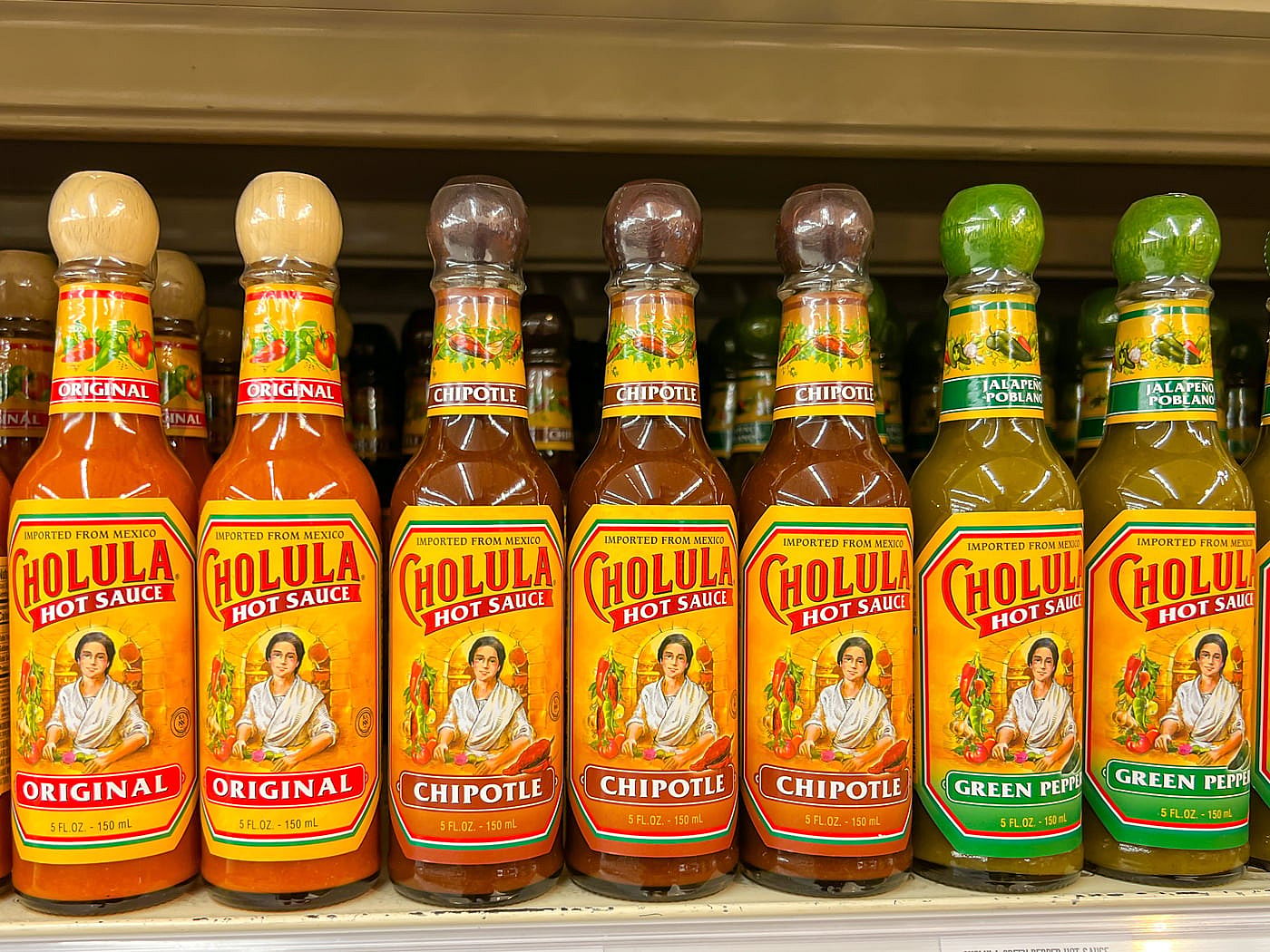 Several bottles of Cholula hot sauce on display at a local grocery store.