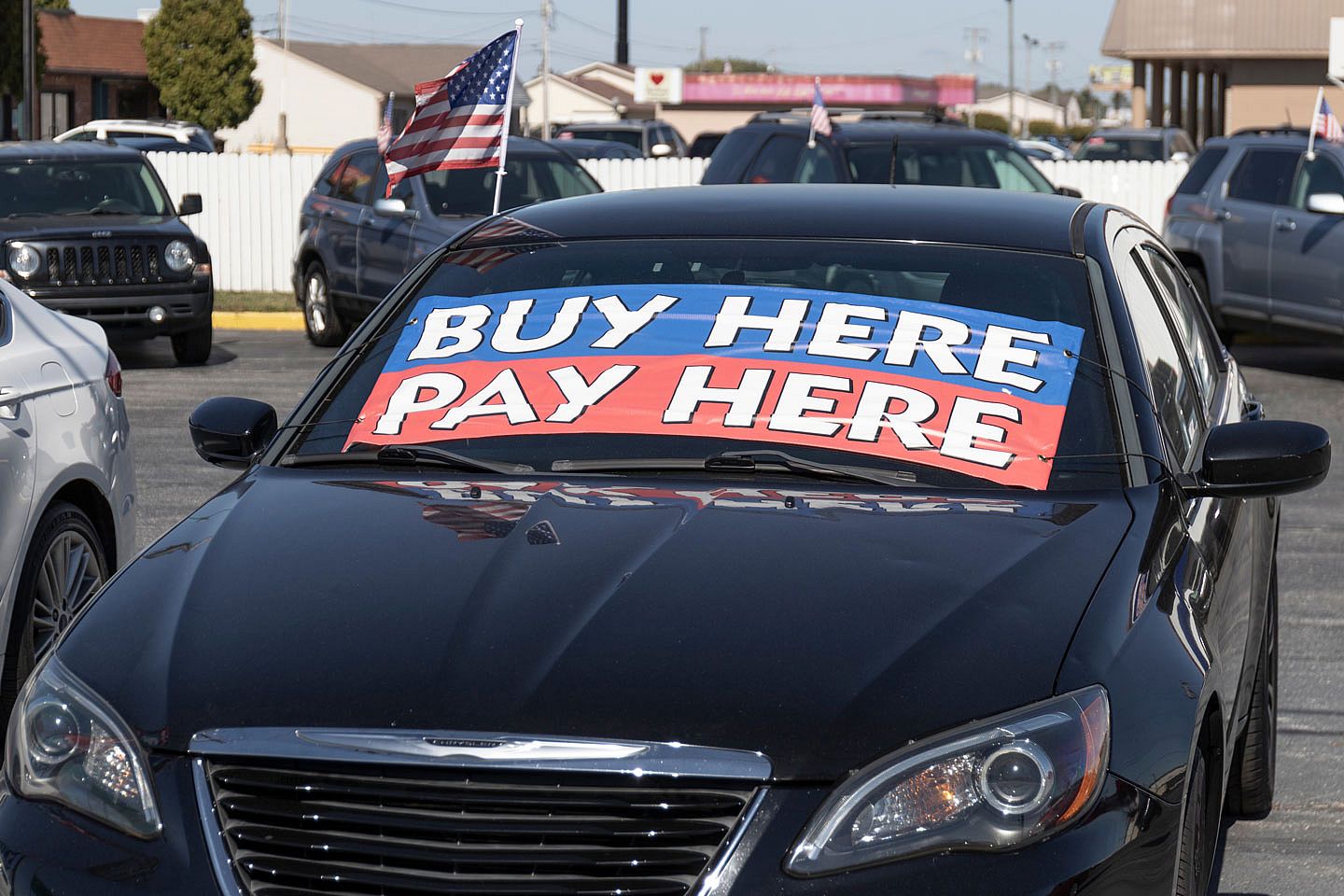 Used car for sale with big signs on the windshield that say Buy here Pay Here