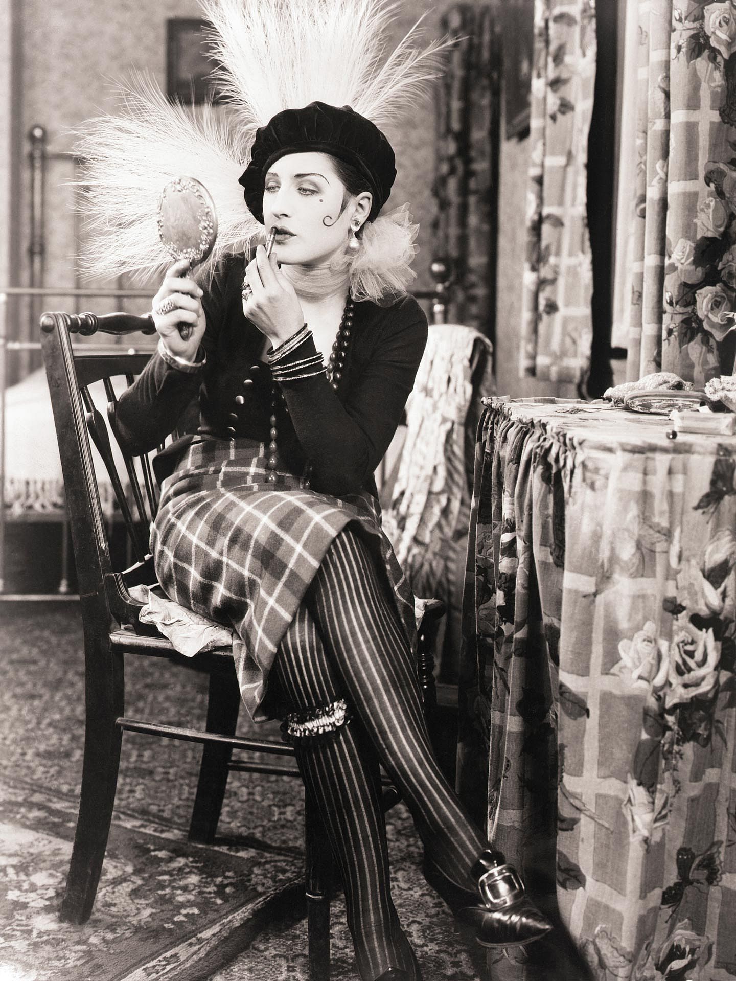 Norma Shearer in a scene from the 1925 Metro-Goldwyn silent, "Lady of the Night." She is seated at her dressing table applying lipstick.