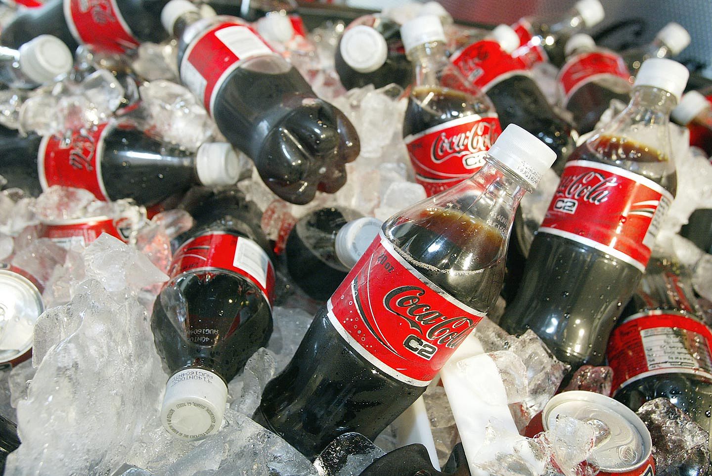 Multiple bottles of Coca-Cola C2 chilling on ice.