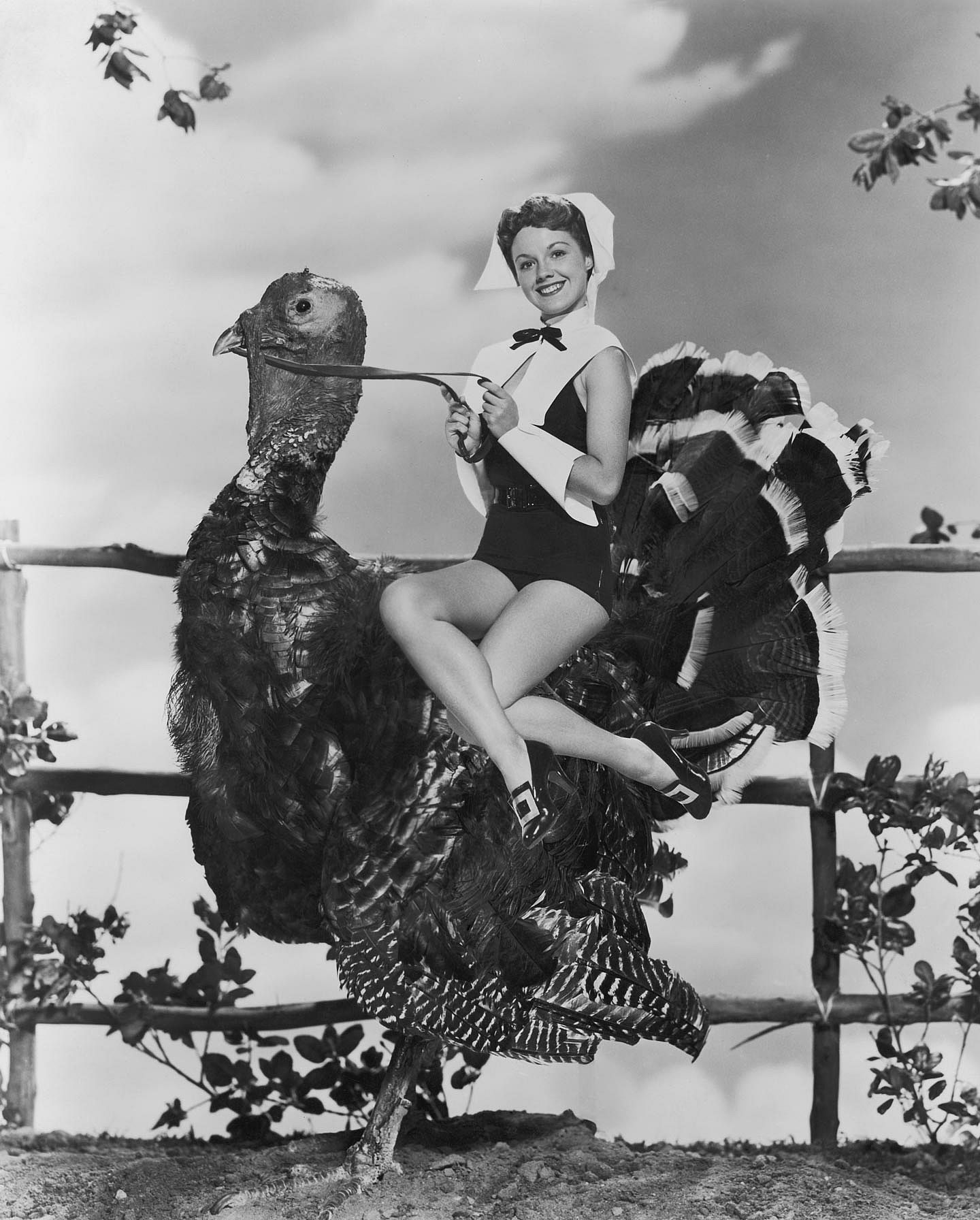 American actress Virginia Gibson, in a glamorous version of puritan costume, rides a giant Turkey, circa 1952.