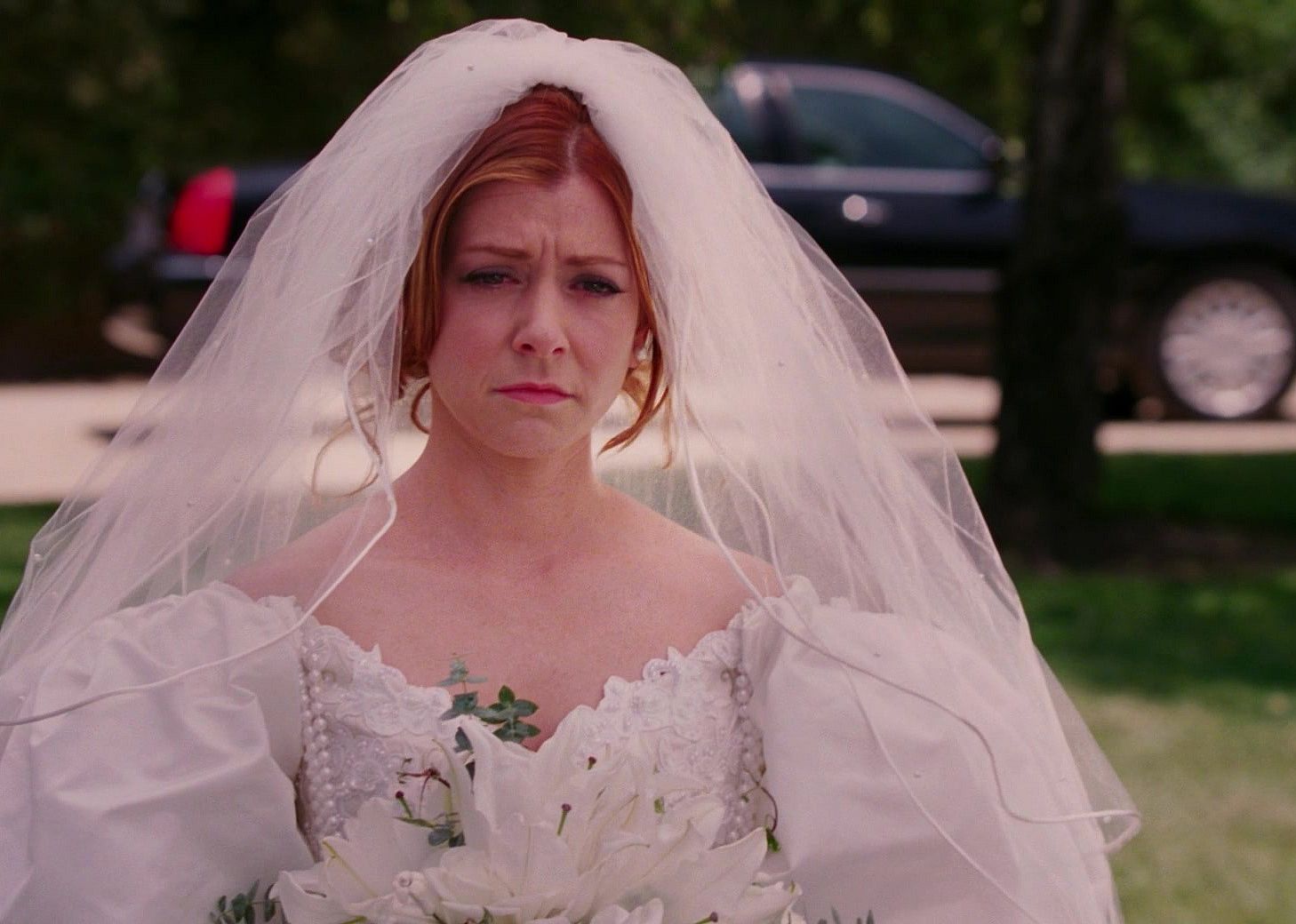 Alyson Hannigan looking sad in an oversized wedding dress.