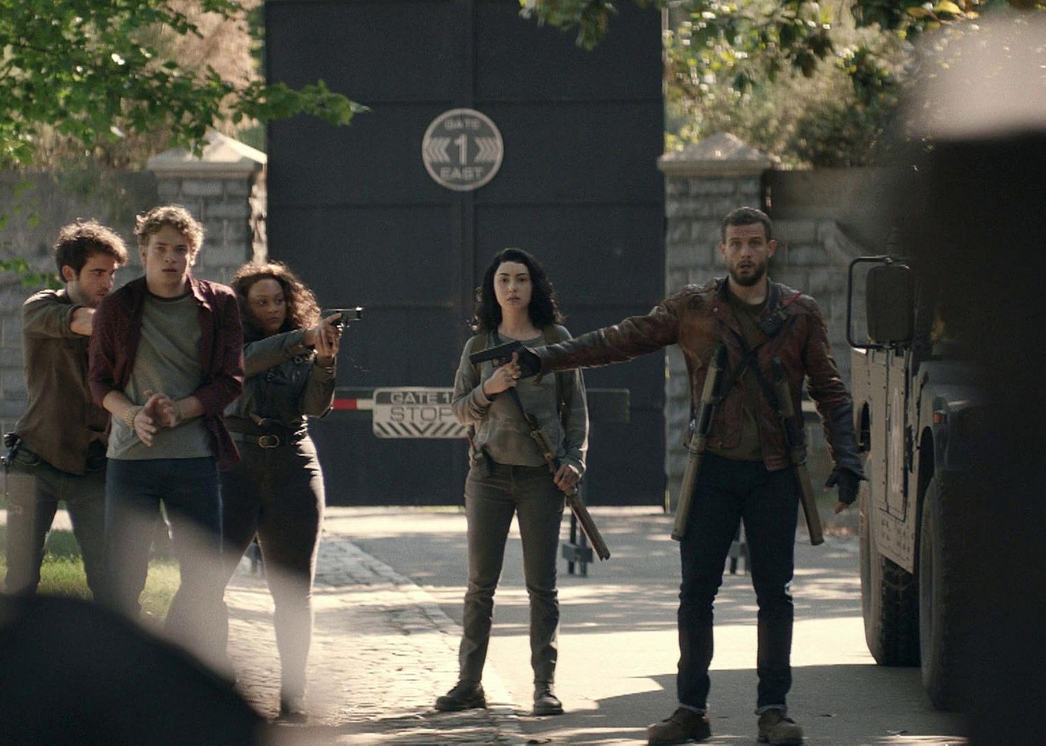 Several young people with guns point them at each other looking confused.