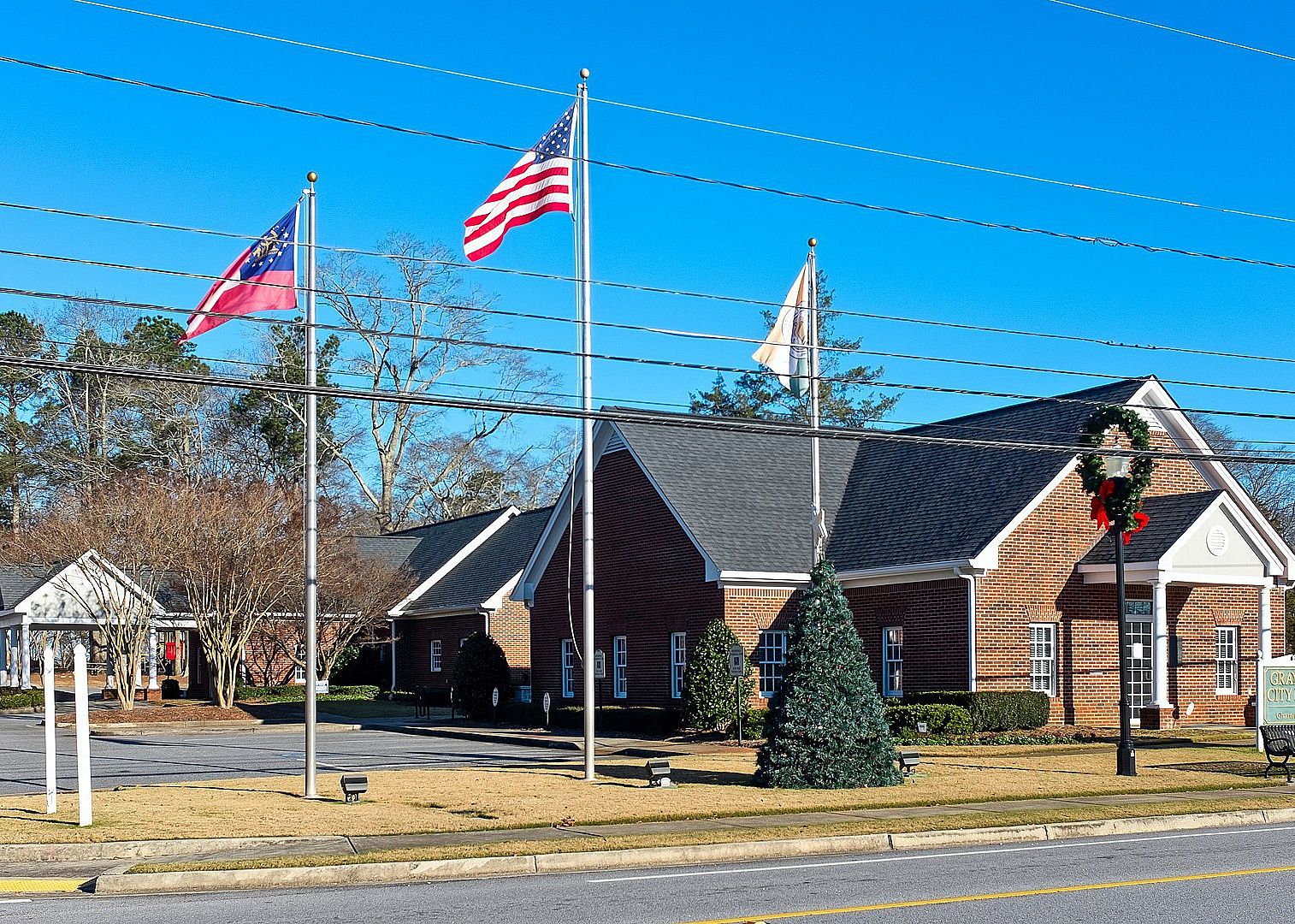 A brick building with flags on the front lawn.