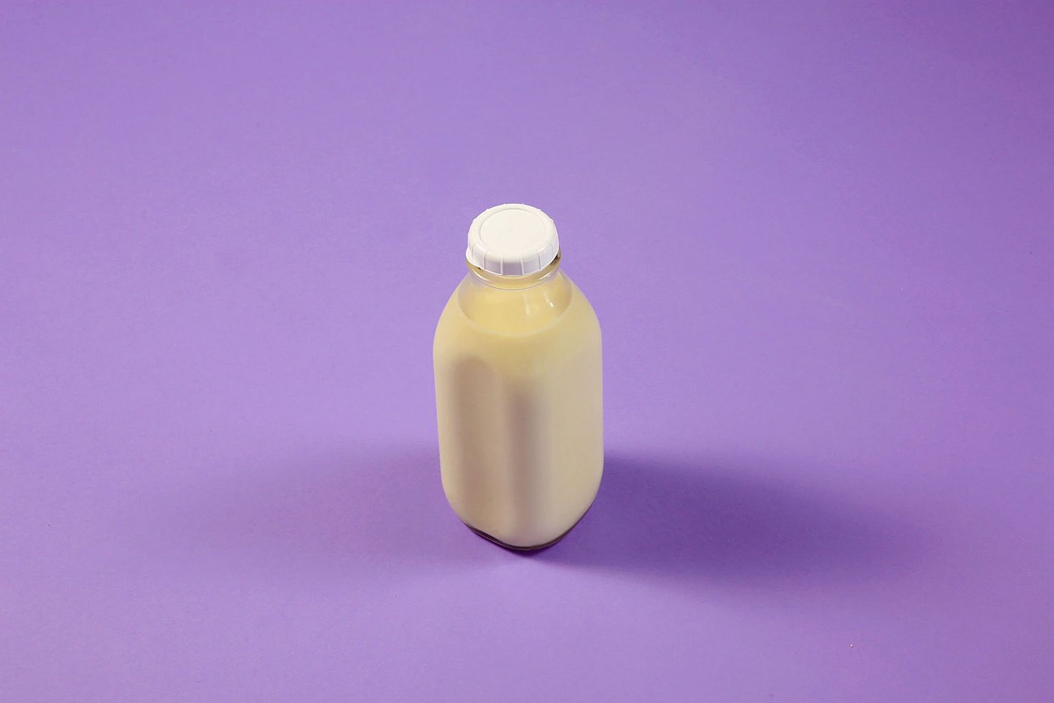 Milk fills a reusable glass bottle
