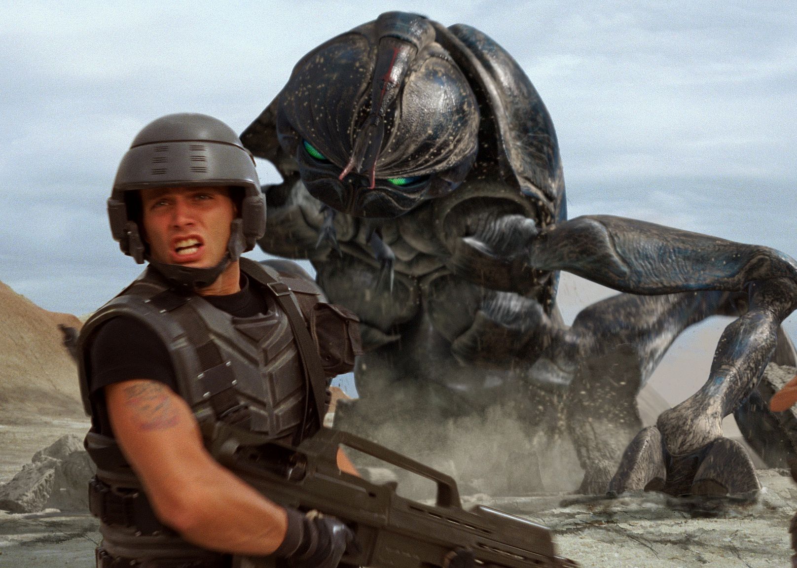 Troopers with guns running in battle with giant alien bugs behind them.