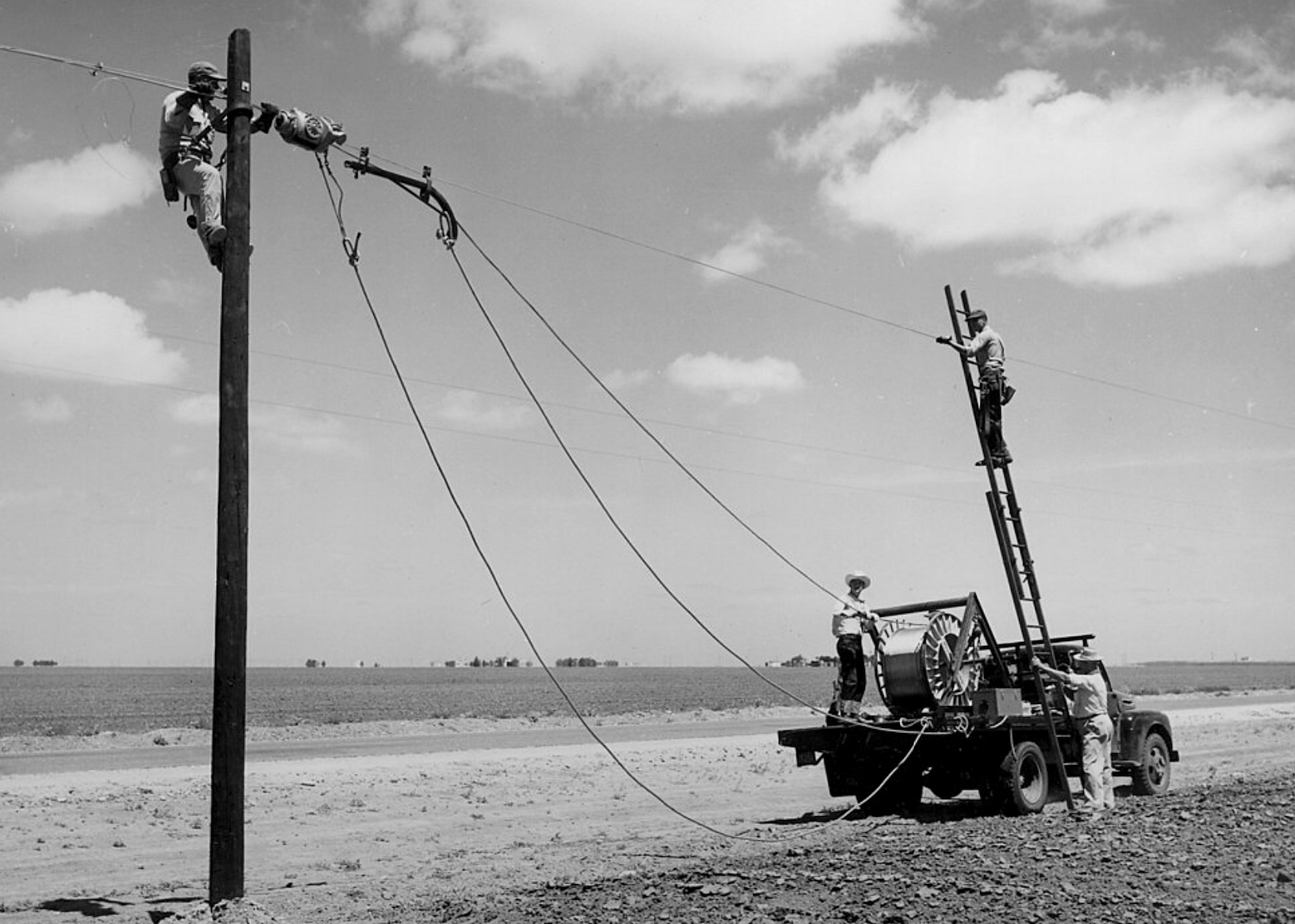 Workers install telephone lines in a rural area
