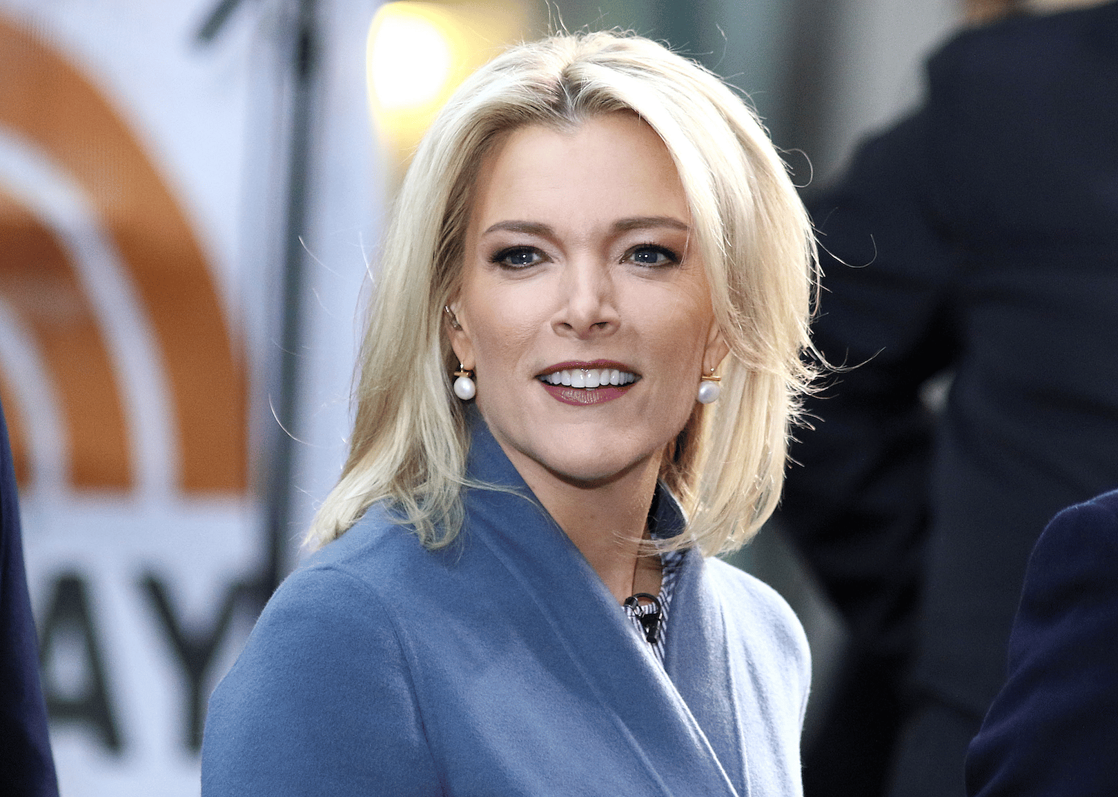Megyn Kelly smiling in a blue coat.