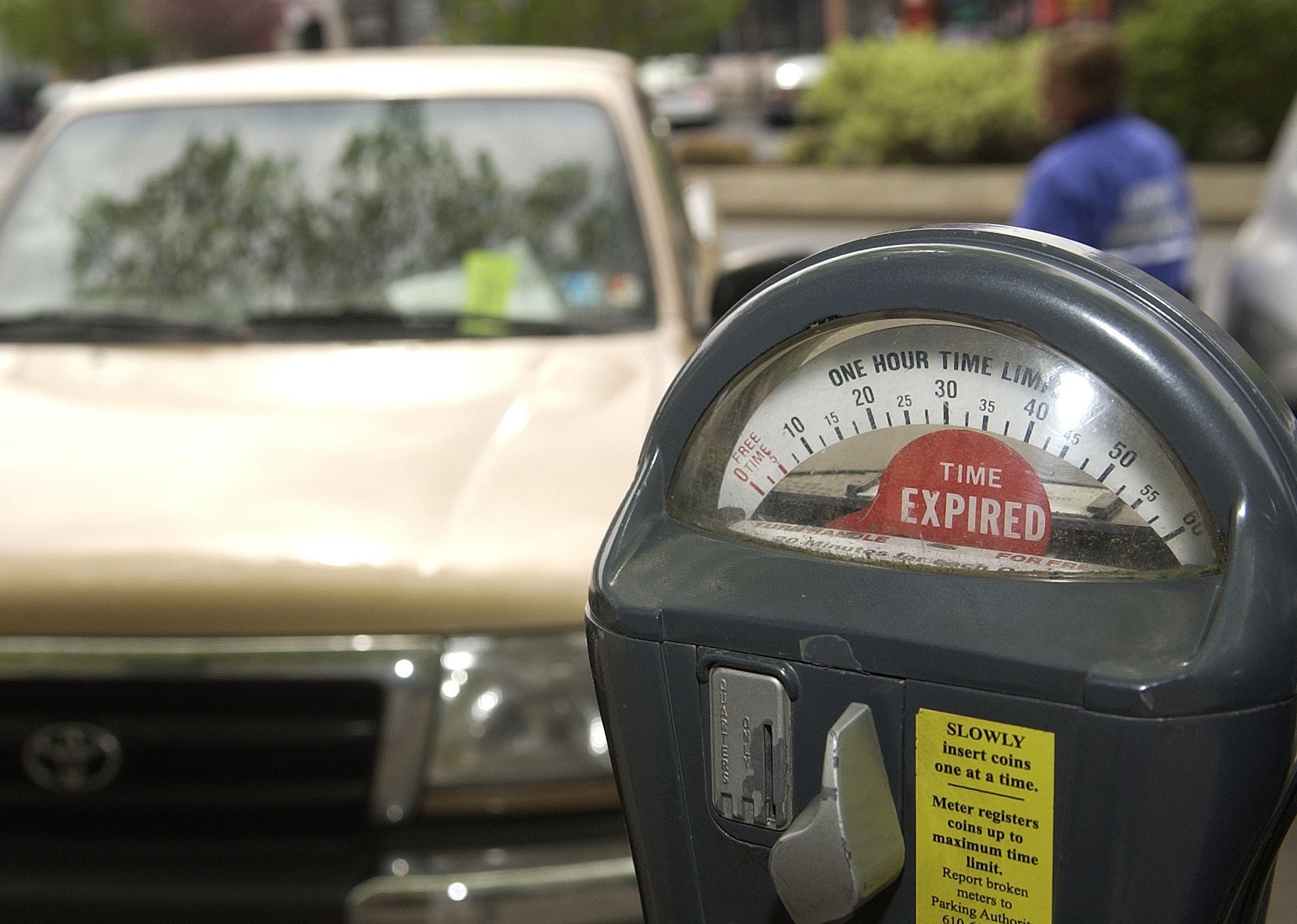 An expired parking meter on the street in front of a truck.