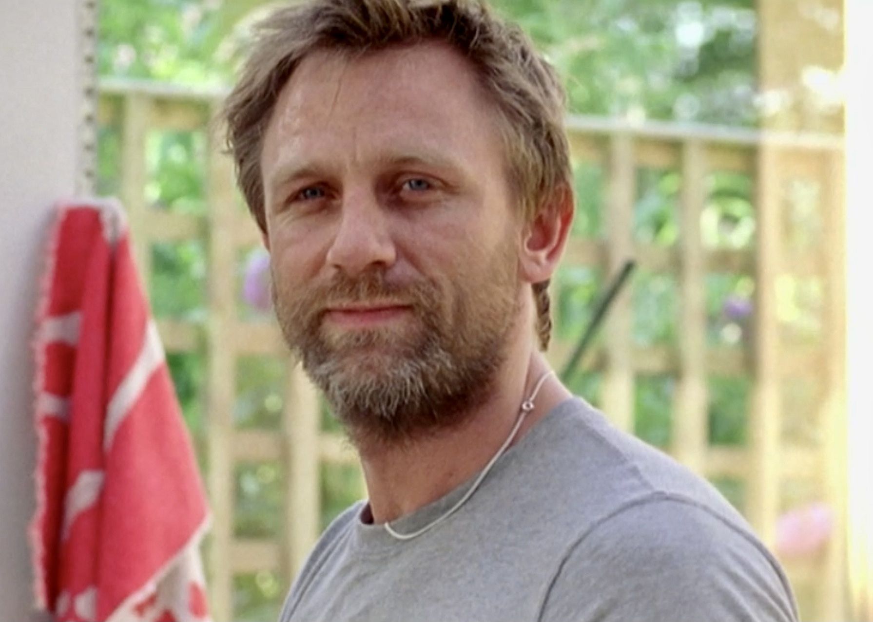 Daniel Craig in a gray t-shirt with a scruffy beard.
